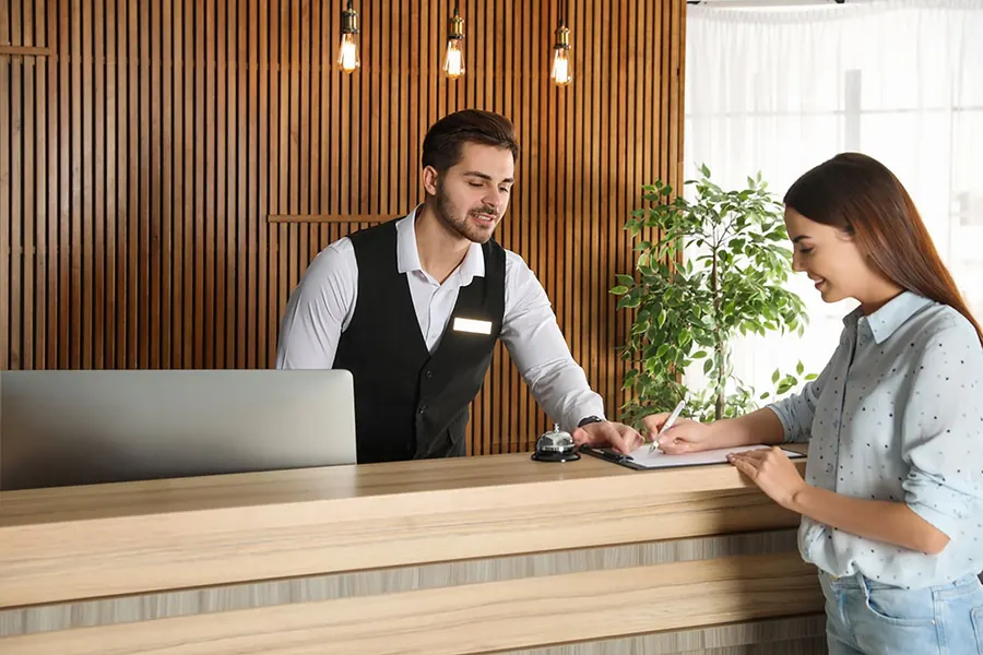 Waiter taking a payment tableside in a busy restaurant